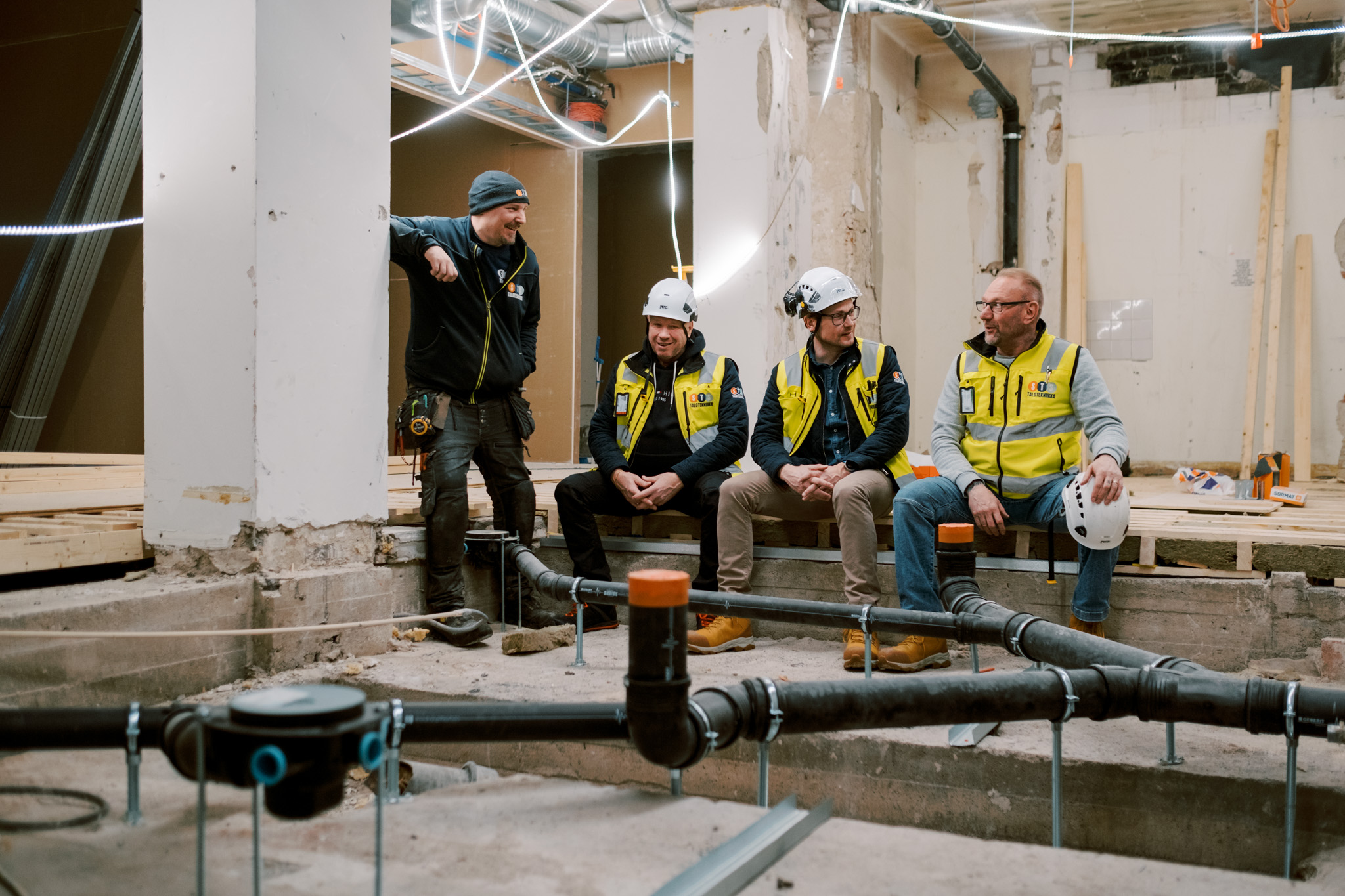 Lvi-ammattilaiset istuvat rennosti purkutyömaalla.